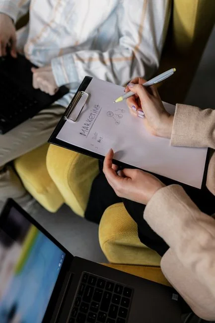 Une équipe variée travaillant ensemble sur des stratégies de marketing digital autour d’une table, avec des ordinateurs portables et des tablettes.